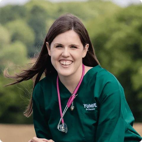 Woman in green scrubs with  logo and stethoscope, outdoors.