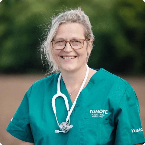 Person wearing teal scrubs with 'YUMOVE' branding, standing outdoors.